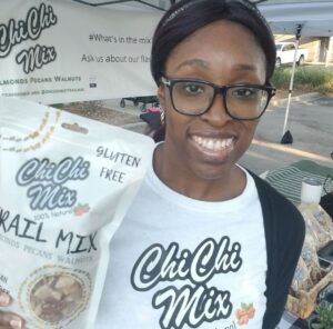 Morayo, a black woman, holding a bag of ChiChi Mix at a farmer's market