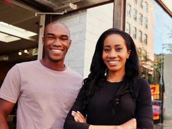 Two people standing side by side, smiling about AOF's non-profit lending model