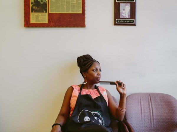 Female business owner holding a comb, considering options for minority business loans to fund her business